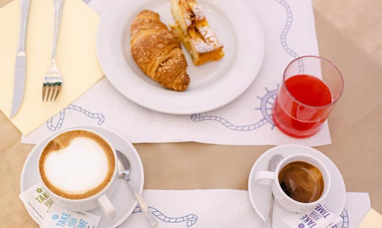 Colazione con dolci, cappuccino, succo e caffè.