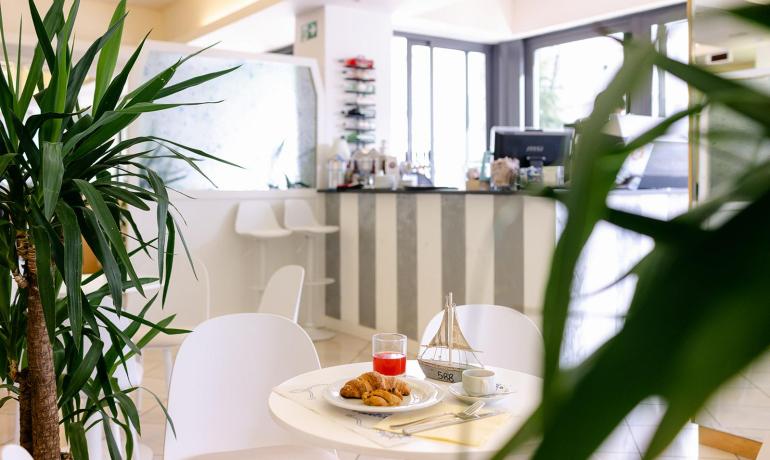 A modern bar with breakfast served on a white table.